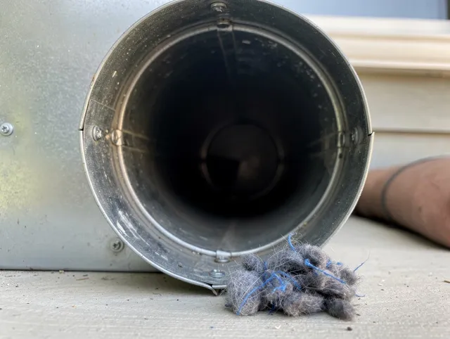 Wilmington Dryer Vent Cleaning technician using specialized equipment to clear severe dryer vent blockage in Wilmington